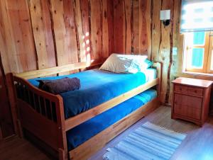 Un pat sau paturi într-o cameră la Cabañas el arrayan neltume +23 fotografii