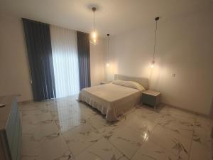 a bedroom with a bed and a large marble floor at Carina Mansion in Birżebbuġa