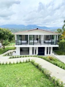 a white house with a balcony and a lawn at Villa Verde in Silvania