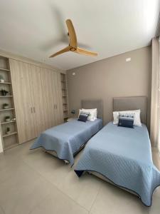 two beds in a bedroom with a ceiling fan at Maison Eden in Armenia +19 photos