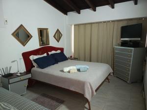 a bedroom with a bed and a dresser with a television at Beach House Terrazas de Guacuco isla de Margarita in Playa Guacuco +21 photos