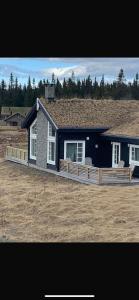 a house with a porch with two chairs in front of it at Hytte hafjell mosetertoppen in Øyer