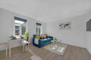 a living room with a blue couch and a table at The Cozy Corner Apartment 1BR Free Parking in Bromley
