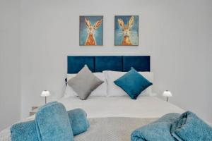 a bedroom with a bed with two blue chairs at The Cozy Corner Apartment 1BR Free Parking in Bromley