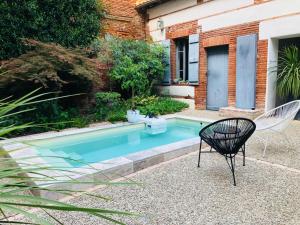 a swimming pool in a garden with a chair next to it at Casita El Lobo in Montech