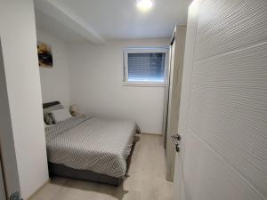 a small bedroom with a bed and a window at Mirna obala in Veliko Gradište