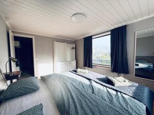 a bedroom with a large bed and a window at Villa Lindesborg in Södertälje +25 photos