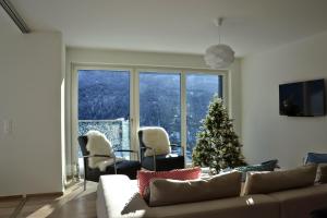 una sala de estar con un árbol de Navidad y un sofá en Panorama Lodge, en Scuol