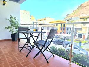 ein Tisch und Stühle auf einem Balkon mit Aussicht in der Unterkunft Villa Herédia in Ribeira Brava