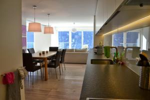 a kitchen and living room with a table and a couch at Panorama Lodge in Scuol