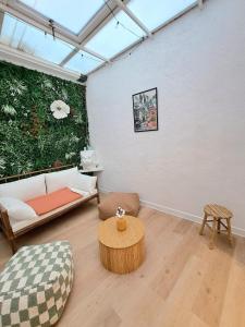 a living room with a couch and a table at Au Détour des Sacres -Hypercentre-Boulingrin in Reims