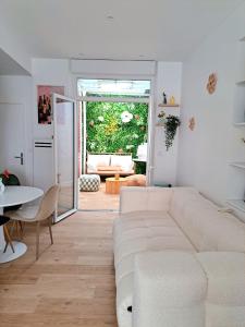 a living room with a white couch and a table at Au Détour des Sacres -Hypercentre-Boulingrin in Reims