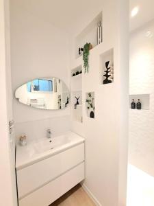 a white bathroom with a sink and a mirror at Au Détour des Sacres -Hypercentre-Boulingrin in Reims