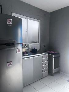 een keuken met een roestvrijstalen koelkast en een raam bij Condomínio Moradas Club Rios do Pará COP 30 in Ananindeua