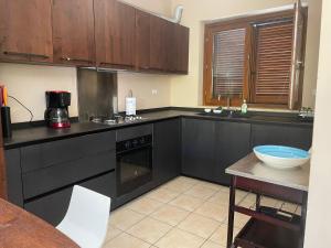 ボルセーナにあるGEM house 30のキッチン(黒いキャビネット、カウンタートップ付) +2枚の写真