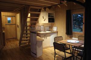 een kleine keuken en eetkamer met een trap in een tiny house bij Domaine des Grands Cèdres in Cordelle