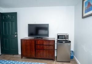 a tv sitting on a wooden stand next to a door at Rainbow Motel in Douglassville