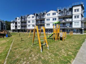 a group of playground equipment in front of a building at Mario Leśny Klif 21 in Debina