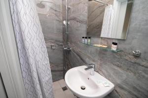 a bathroom with a sink and a shower at Thines Studios - Studio B in Kefalos +8 photos