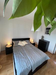 a bedroom with a bed and two tables with lamps at Apartment Loft Fifteen in Dunajská Streda