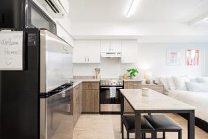 a kitchen and living room with a refrigerator and a table at Top Location - Cozy & Bright MTL studio near metro in Montréal