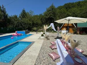 a swimming pool with a table and an umbrella at FiP Pure in Foča