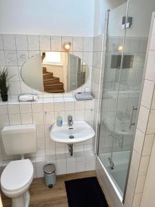 a bathroom with a toilet and a sink and a mirror at Home&Living - Casa Blue in Meerbusch