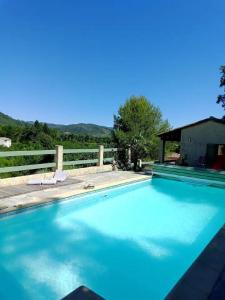 einen Pool mit blauem Wasser und einem Zaun in der Unterkunft La Maison de Graviès in Anduze