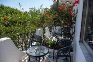 two chairs and a table on a balcony with flowers at Thines Studios - Studio B in Kefalos
