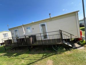 a mobile home with a porch on the side of it at Kings Caravan Park A-56 in Chapel Saint Leonards