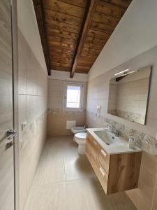 a bathroom with a toilet and a sink and a mirror at Mare Fuori in Gonnesa +12 photos