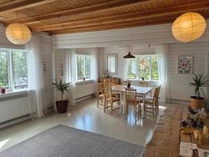 a dining room with a table and chairs and windows at Skaftholt Guesthouse in Birkikinn