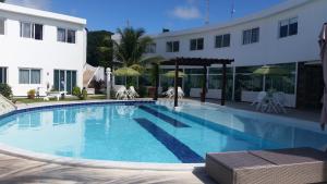 a large swimming pool in front of a building at Mandakaru Residence Flats in Porto De Galinhas