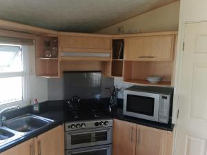 a kitchen with a stove and a microwave at Beautiful scenery in Startforth