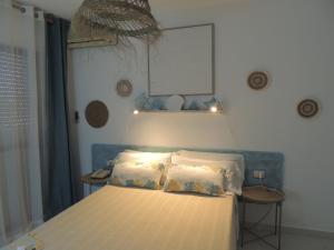 a bed with two pillows and a lamp in a bedroom at LOS NAREJOS Hotel in Los Alcázares