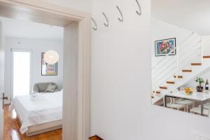 una camera bianca con un letto e una scala di New Gallery Apartment with Beautiful View a Baška Voda