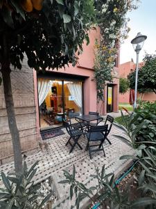 a patio with a table and chairs in front of a building at Dar Fayz in Marrakesh