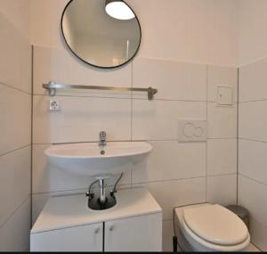 a bathroom with a sink and a toilet and a mirror at Rooms ETVY, Tv AC in Ulcinj