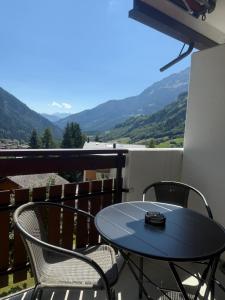a table and chairs on a balcony with mountains at Goliath 44 & 45 in Leukerbad