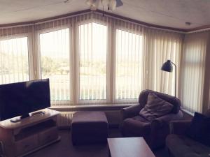 a living room with a couch and a tv and windows at Beautiful scenery in Startforth