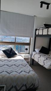 コキンボにあるDepartamento con vista al mar y cruz del tercer milenio Coquimbohouseのベッドと大きな窓のある寝室