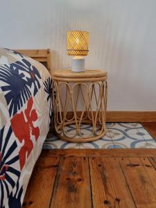 a lamp on a table next to a bed at N3 - Charmant Studio Central in Valenciennes
