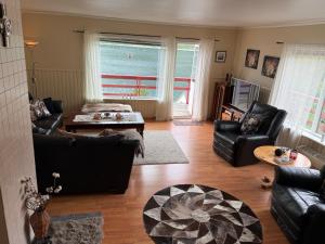 a living room with leather furniture and a view of the ocean at Rifi Senja House in Senja
