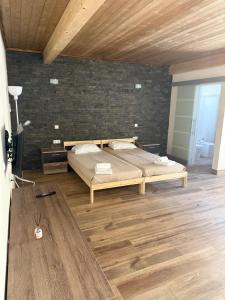 グランドラにあるCasa dos Diogosのベッドとレンガの壁がある寝室