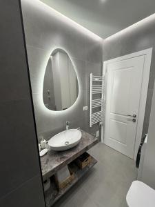 a bathroom with a sink and a mirror at Azure Apartments in Korçë +10 photos