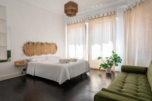 a white bedroom with a bed and a couch at HT MIRIBILLA habitaciones turísticas sin ascensor in Bilbao