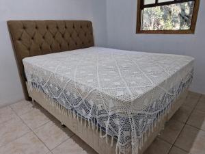 a bed in a room with a white bedspread at Lacaune Haus in São Francisco de Paula