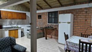 a kitchen with a white refrigerator and a table at Lacaune Haus in São Francisco de Paula