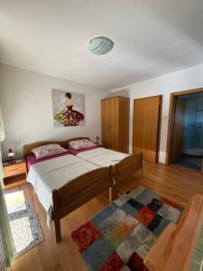 a bedroom with a bed and a rug at Plitvice Pension Perisic in Korenica