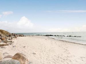 a sandy beach with rocks and the ocean at Luxury Wellness Retreat - By Traum Ferienwohnungen in Stege